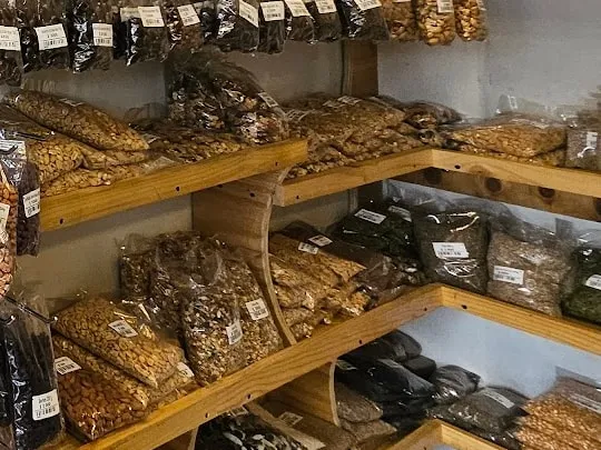 Repisas de madera con bolsas grandes de frutos secos y semillas